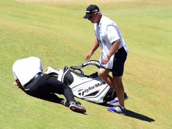 UNIVERSITY PLACE, WA - JUNE 19:  Jason Day of Australia is tended to by caddie Colin Swatton as he lays on the ninth green after falling due to dizziness during the second round of the 115th U.S. Open Championship at Chambers Bay on June 19, 2015 in University Place, Washington.  (Photo by Harry How/Getty Images)
